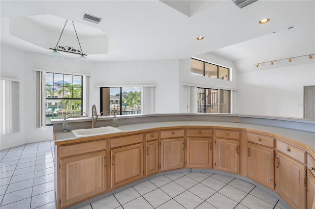 kitchen featuring sink, vaulted ceiling, and light tile patterned flooring