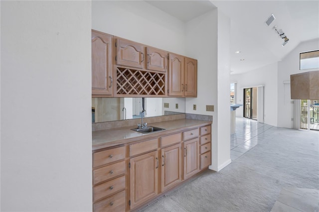 kitchen with light carpet, sink, high vaulted ceiling, and rail lighting