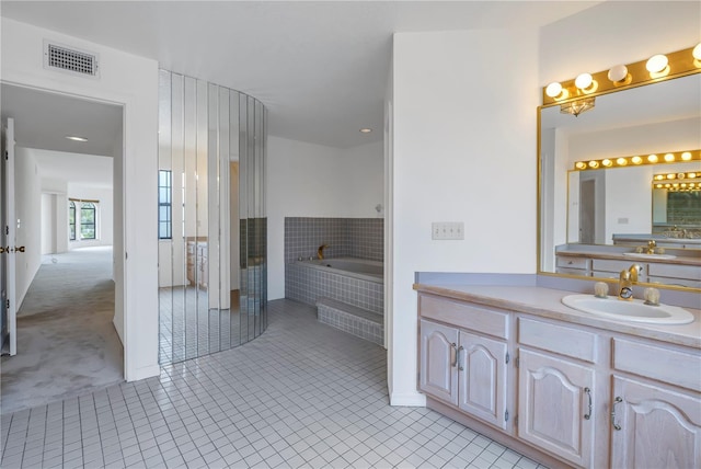 bathroom with vanity, tiled bath, and tile patterned floors