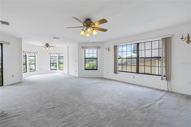 carpeted spare room with ceiling fan and a wealth of natural light