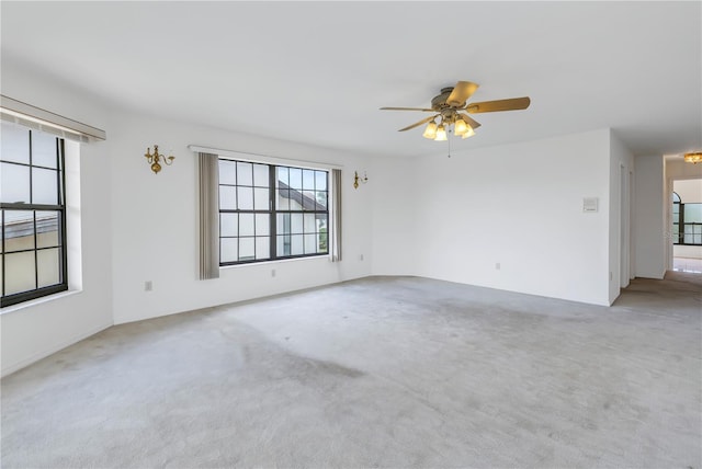 spare room with ceiling fan and light carpet