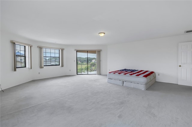 unfurnished bedroom featuring access to exterior and carpet