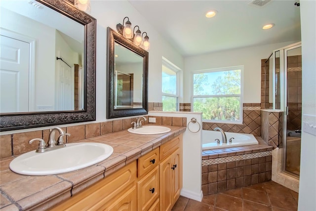 bathroom featuring vanity, plus walk in shower, and tile patterned flooring