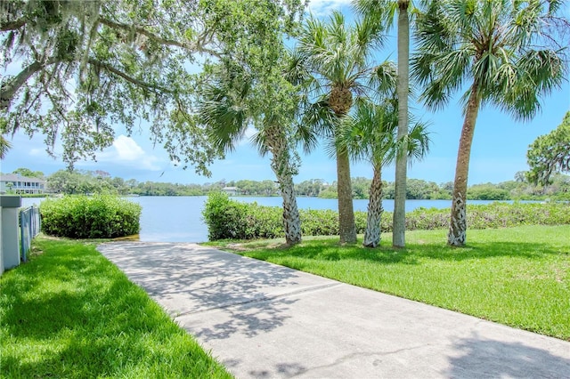 view of home's community with a water view and a lawn