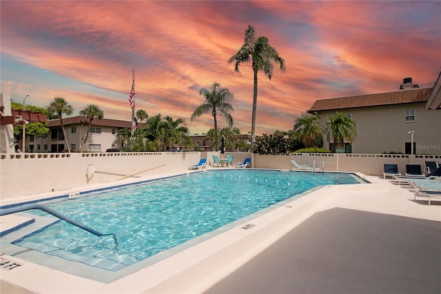 pool at dusk featuring a patio