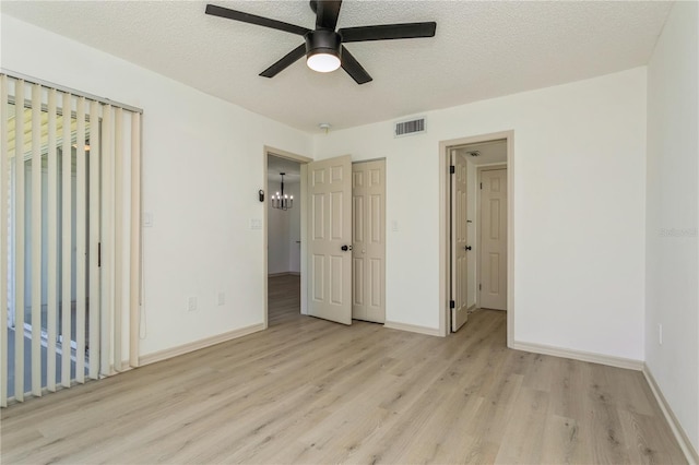 unfurnished bedroom featuring ceiling fan, light hardwood / wood-style floors, and a textured ceiling