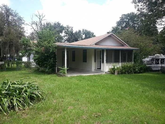 back of property with a yard and a patio