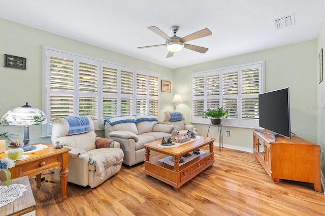 living room with light hardwood / wood-style flooring and ceiling fan