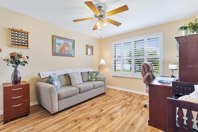 home office with light hardwood / wood-style floors and ceiling fan