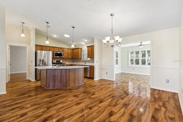 kitchen with vaulted ceiling, appliances with stainless steel finishes, decorative backsplash, and pendant lighting