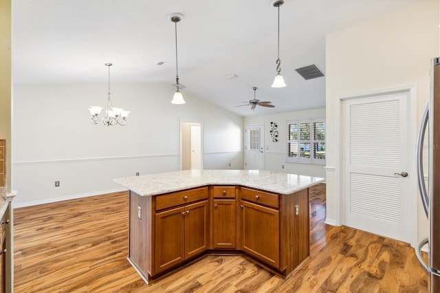 kitchen with light hardwood / wood-style floors, lofted ceiling, a center island, and hanging light fixtures