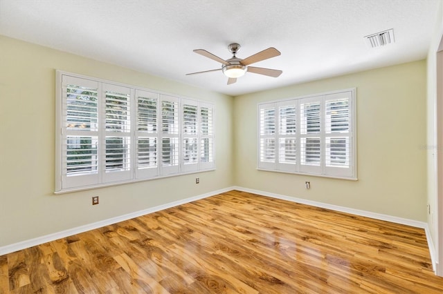 unfurnished room featuring light hardwood / wood-style flooring, a textured ceiling, and ceiling fan