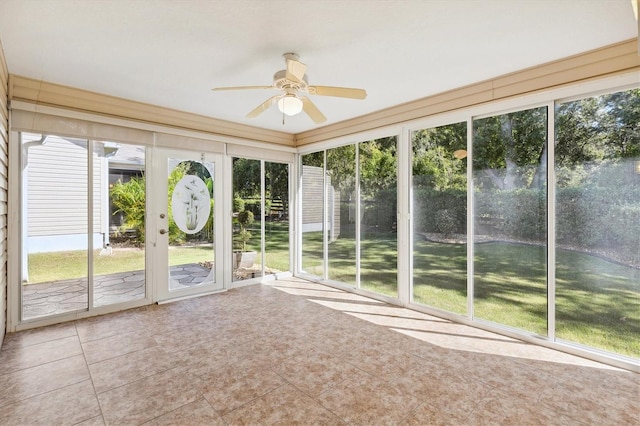 unfurnished sunroom featuring ceiling fan