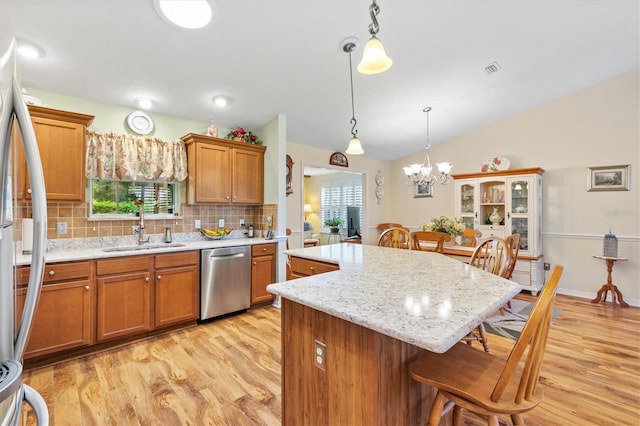 kitchen with sink, a healthy amount of sunlight, dishwasher, and pendant lighting