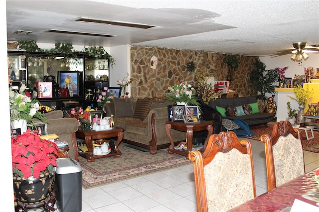 tiled living room featuring ceiling fan and a textured ceiling