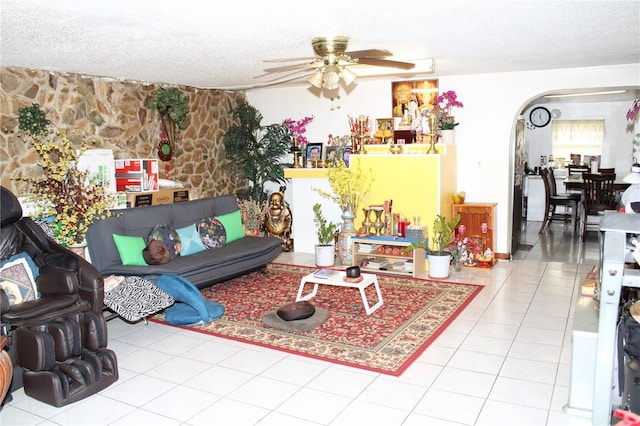 tiled living room featuring ceiling fan and a textured ceiling