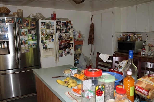 kitchen with tasteful backsplash, appliances with stainless steel finishes, and white cabinets