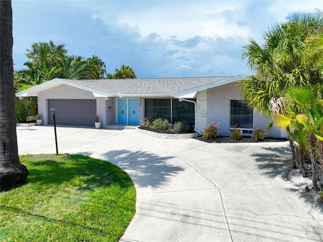 ranch-style house featuring a garage and a front lawn