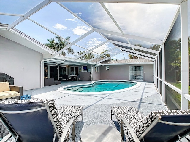 view of pool with glass enclosure and a patio