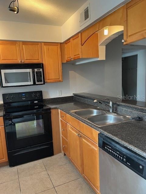 kitchen with sink, light tile patterned floors, and stainless steel appliances