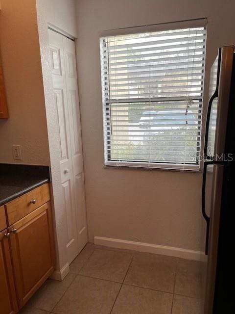 kitchen with light tile patterned floors and fridge