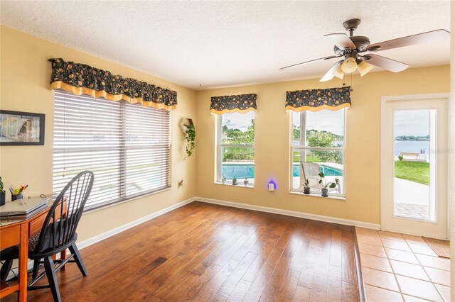 dining area with a textured ceiling, hardwood / wood-style flooring, and ceiling fan