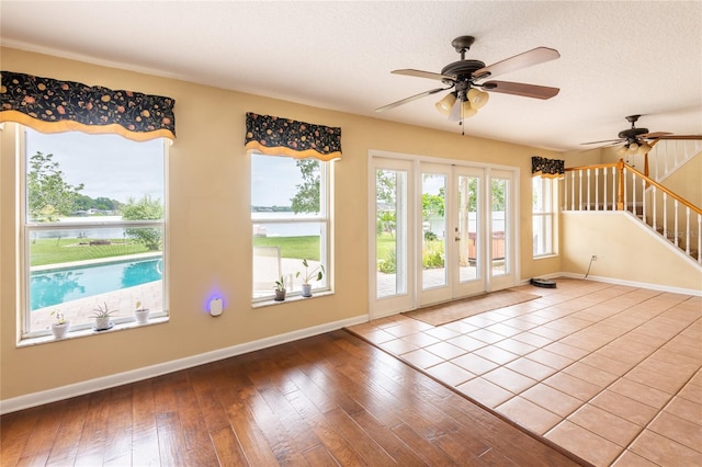 doorway featuring a textured ceiling, french doors, wood-type flooring, and ceiling fan