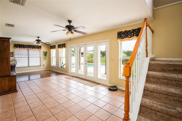 doorway to outside with french doors, a textured ceiling, ceiling fan, and light tile patterned flooring