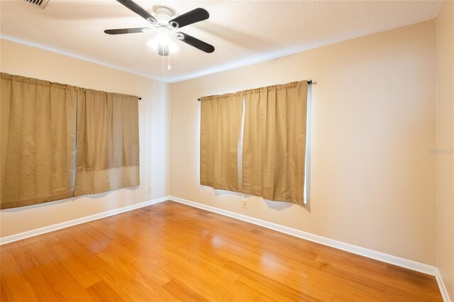 spare room with a textured ceiling, hardwood / wood-style floors, and ceiling fan