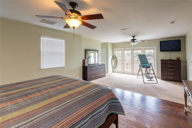 carpeted bedroom with ceiling fan and a textured ceiling