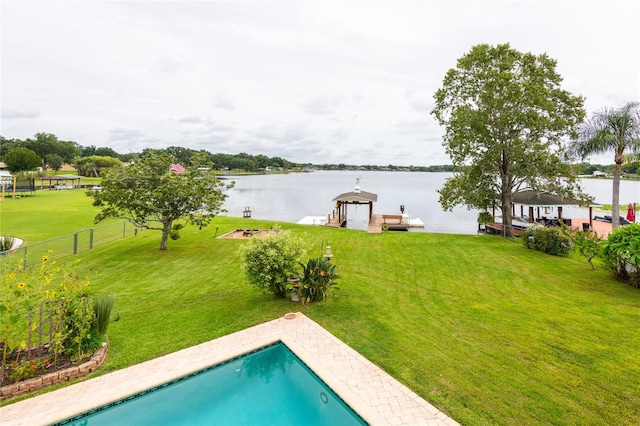 view of swimming pool featuring a dock, a yard, and a water view