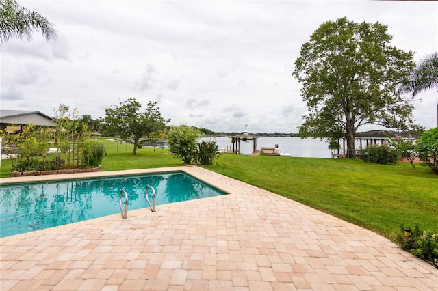 view of swimming pool featuring a water view, a lawn, and a patio