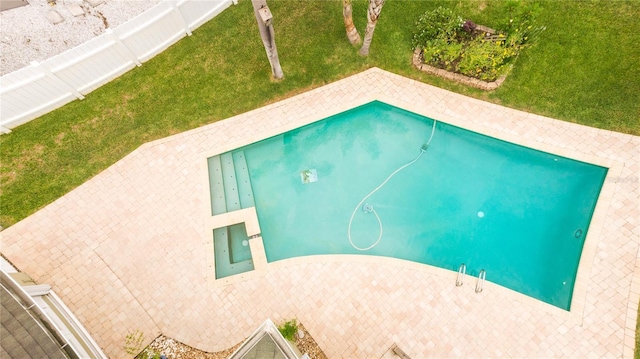 view of pool with a patio and a yard