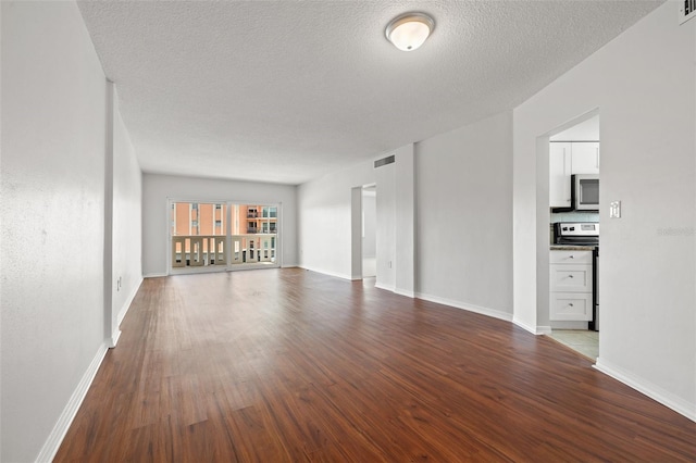 unfurnished living room with wood-type flooring and a textured ceiling