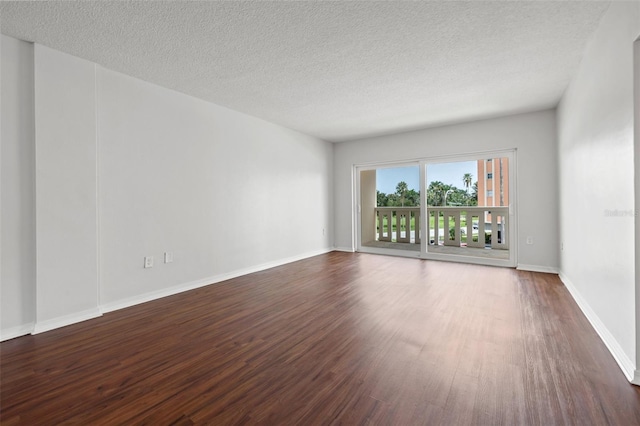 spare room featuring a textured ceiling and hardwood / wood-style flooring