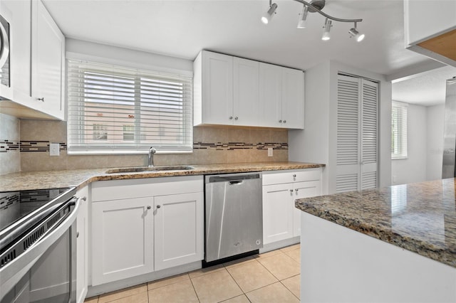 kitchen featuring white cabinets, light tile patterned floors, stainless steel appliances, and tasteful backsplash