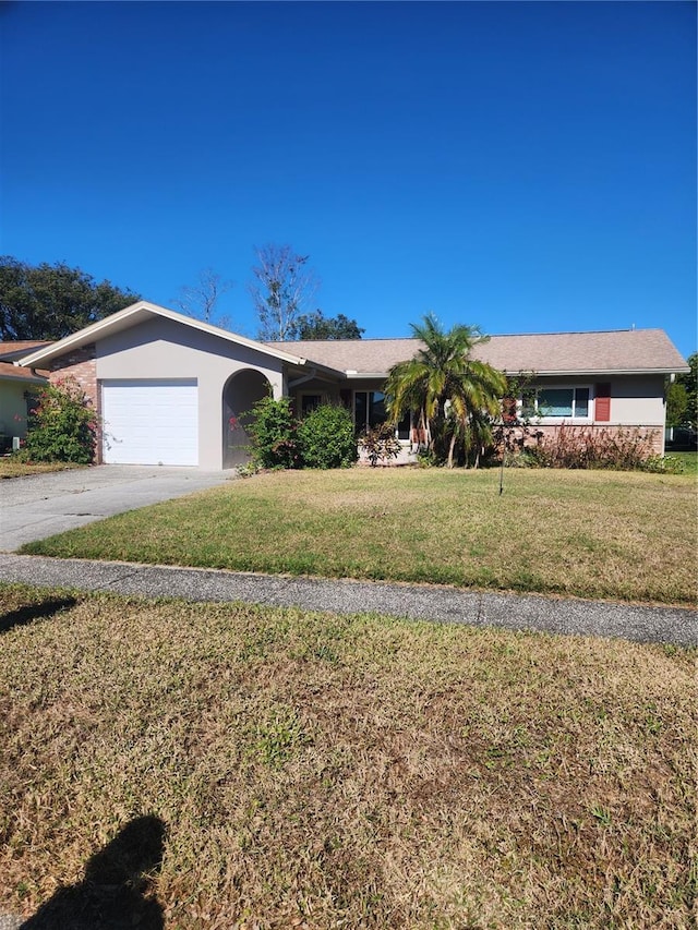 ranch-style house with a garage and a front lawn