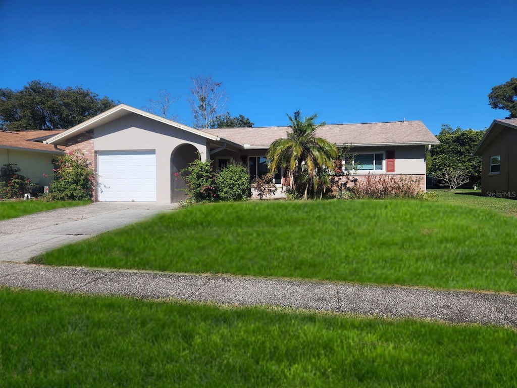 ranch-style home featuring a garage and a front yard