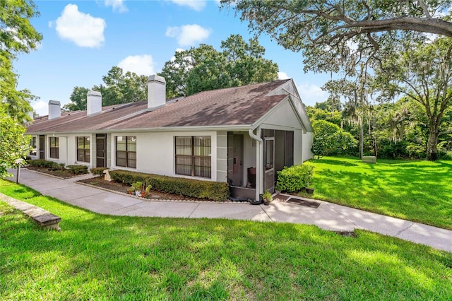 view of front of property featuring a sunroom and a front yard