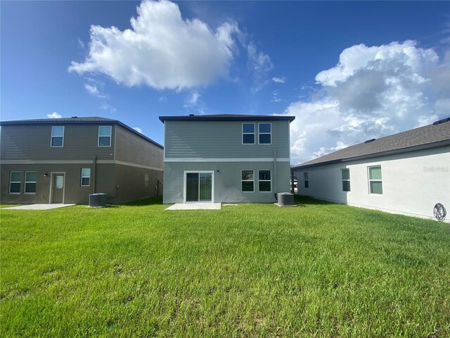 rear view of house with a patio area, a lawn, and central AC unit