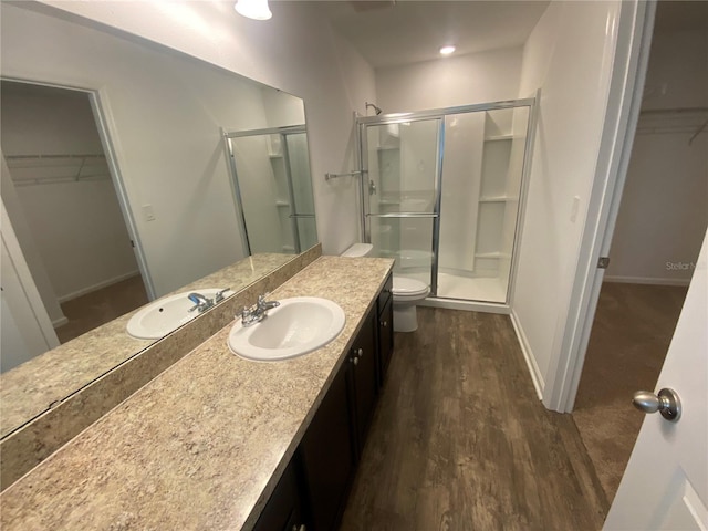 bathroom featuring hardwood / wood-style floors, an enclosed shower, vanity, and toilet