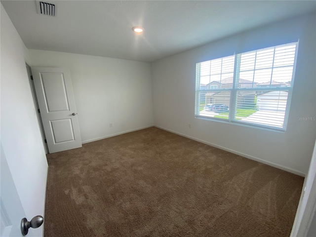 unfurnished room featuring dark colored carpet