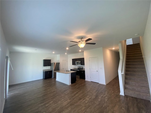 kitchen featuring appliances with stainless steel finishes, dark hardwood / wood-style flooring, sink, a kitchen island with sink, and ceiling fan