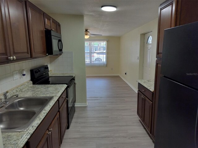 kitchen with black appliances, ceiling fan, decorative backsplash, sink, and light hardwood / wood-style flooring