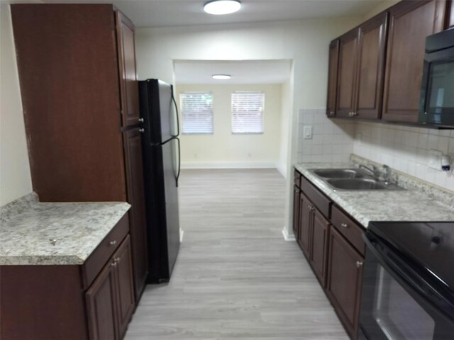 kitchen with light hardwood / wood-style flooring, dark brown cabinets, sink, backsplash, and refrigerator