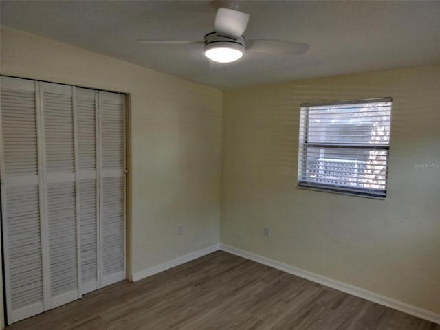 unfurnished bedroom with hardwood / wood-style flooring, a closet, and ceiling fan