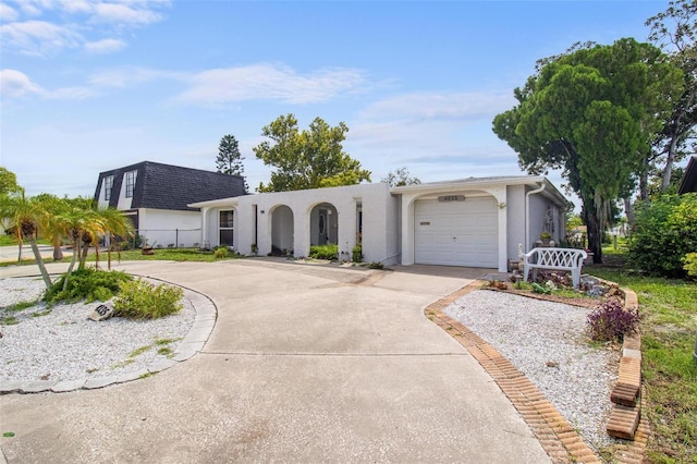 view of front of house featuring concrete driveway, a shingled roof, an attached garage, and stucco siding