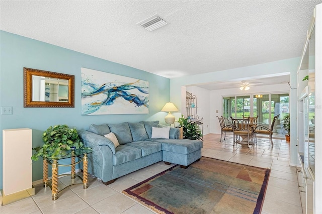 living area with visible vents, a textured ceiling, and light tile patterned flooring