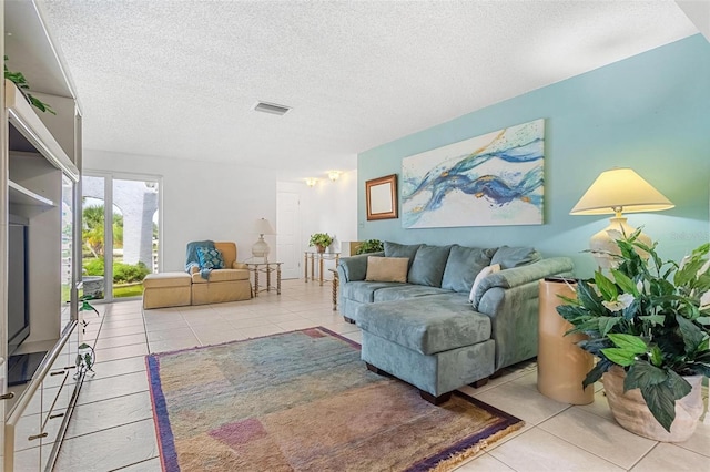 tiled living room featuring visible vents and a textured ceiling