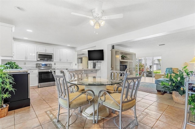 dining area with light tile patterned floors, a ceiling fan, a textured ceiling, and recessed lighting